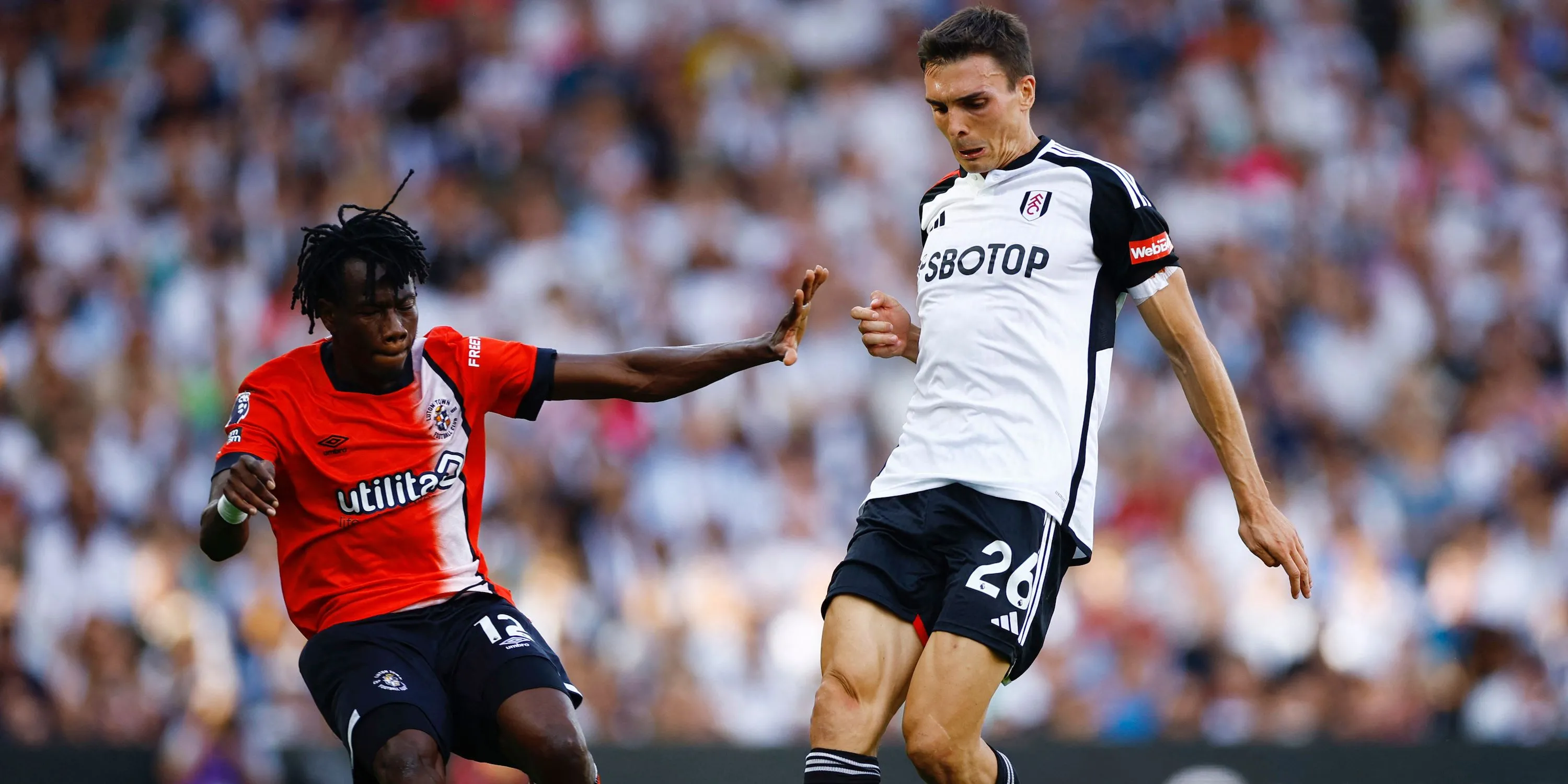 Tiền vệ João Palhinha của Fulham tranh chấp bóng với Issa Kabore của Luton Town